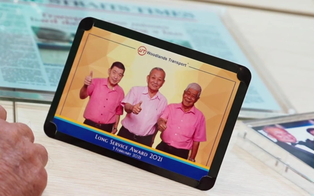 A tablet in the Woodlands heritage collection displays a 2021 long-service tribute photograph