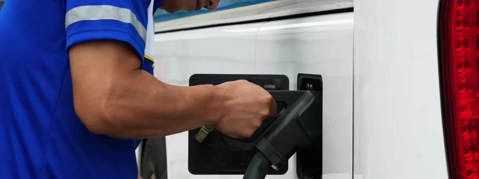 An operator connecting an electric commercial vehicle to a charger